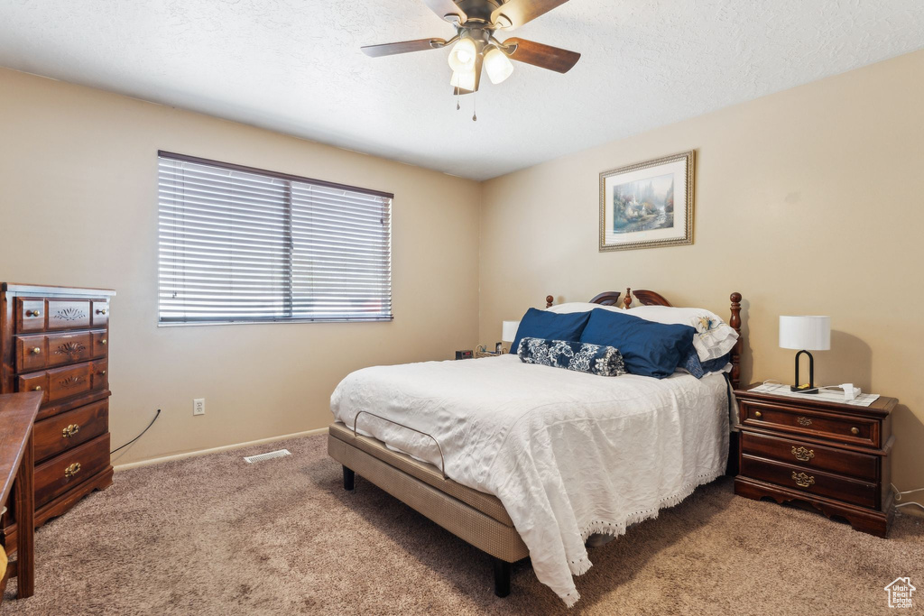 Bedroom with carpet, baseboards, and a ceiling fan