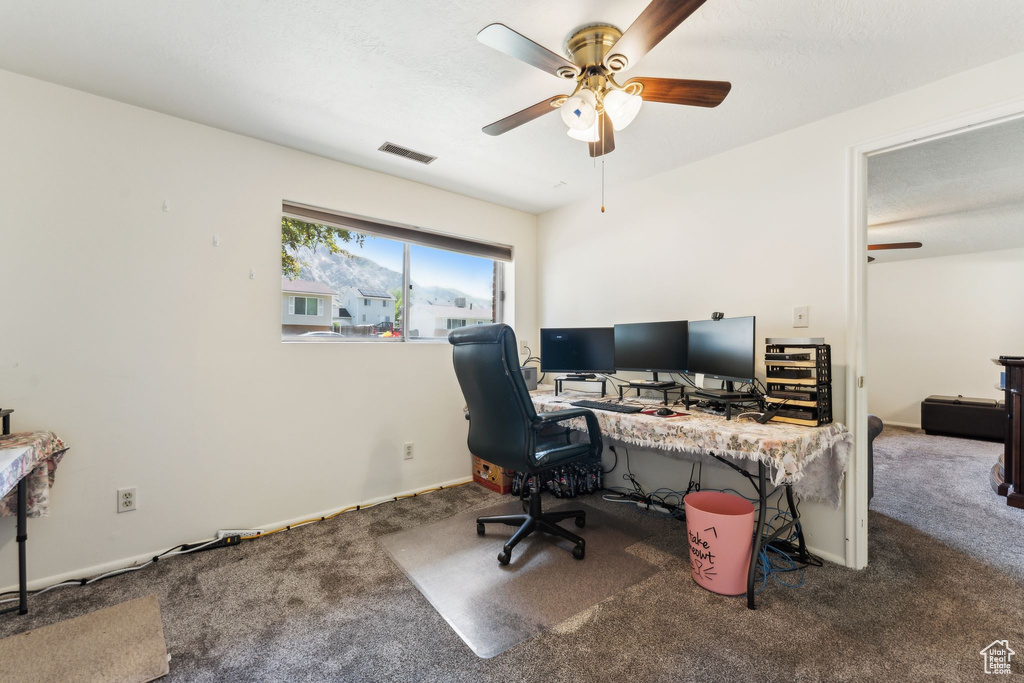 Home office with ceiling fan, carpet, and baseboards