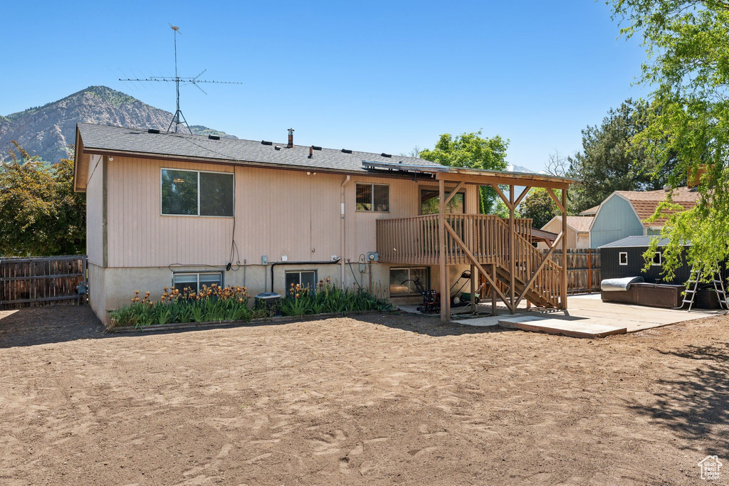 Back of house featuring a patio area, a fenced backyard, stairs, and a deck with mountain view