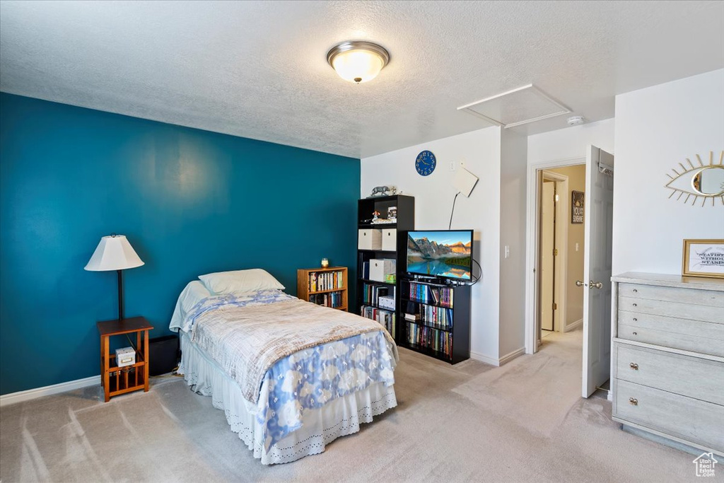 Bedroom featuring carpet floors, a textured ceiling, and baseboards