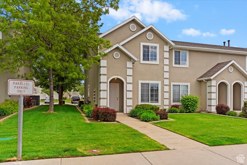 Multi unit property featuring stucco siding and a front lawn
