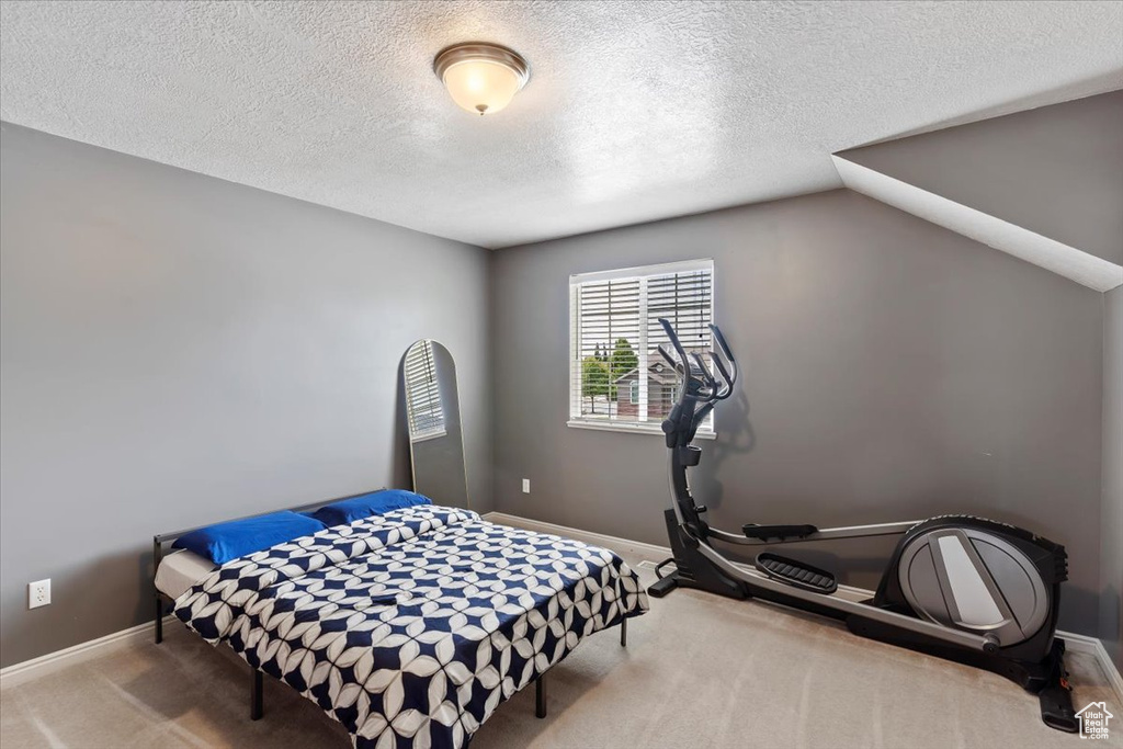 Carpeted bedroom with a textured ceiling and baseboards