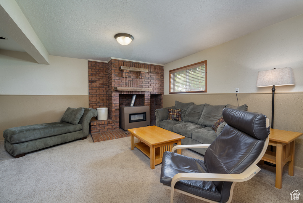 Carpeted living area featuring a fireplace and a textured ceiling