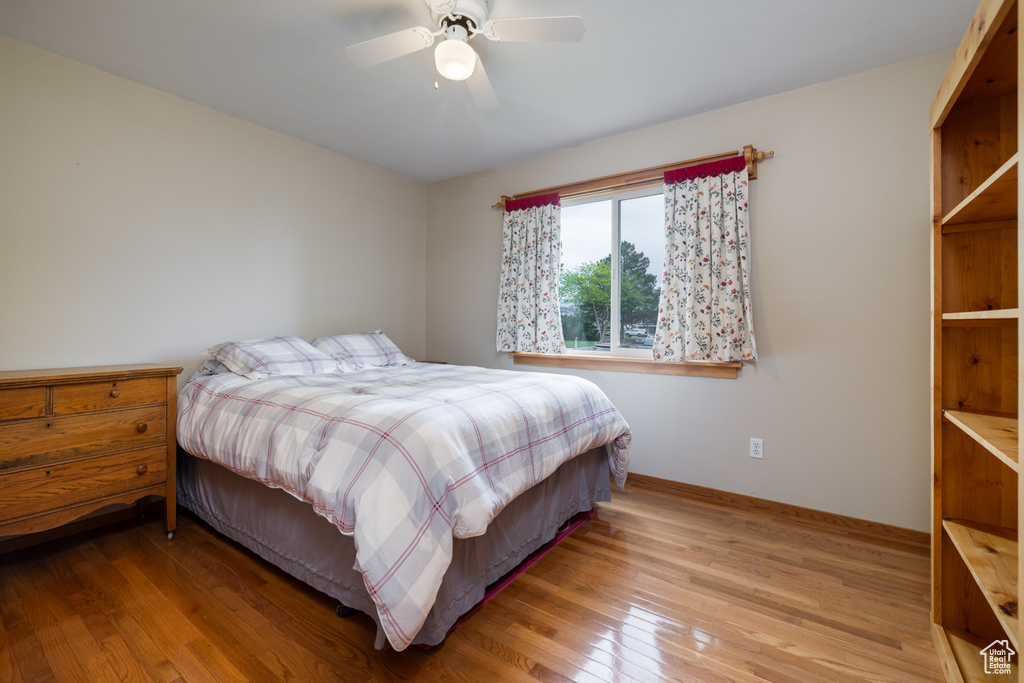 Bedroom featuring wood finished floors, baseboards, and ceiling fan