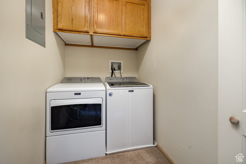 Laundry room featuring cabinet space, electric panel, washer and dryer, and carpet floors