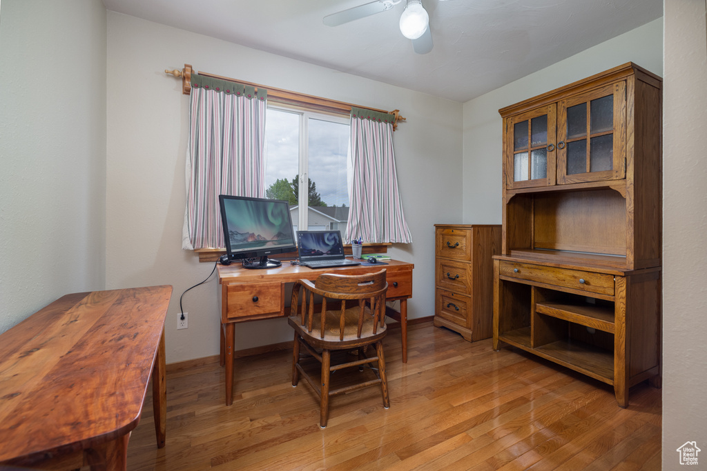 Office area with a ceiling fan and light wood finished floors
