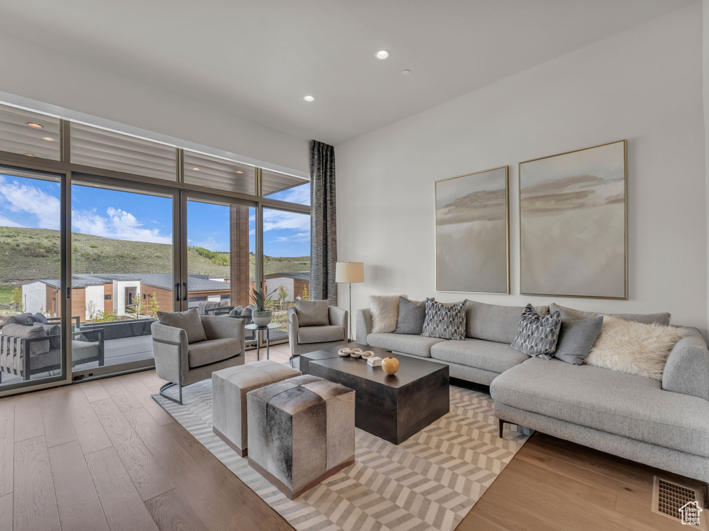Living room with light wood-type flooring and recessed lighting