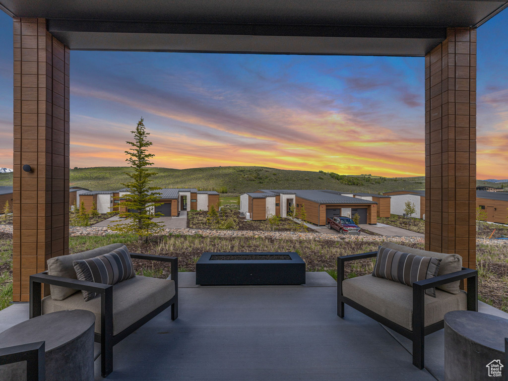 Patio terrace at dusk featuring a patio, a mountain view, an outbuilding, and an outdoor hangout area