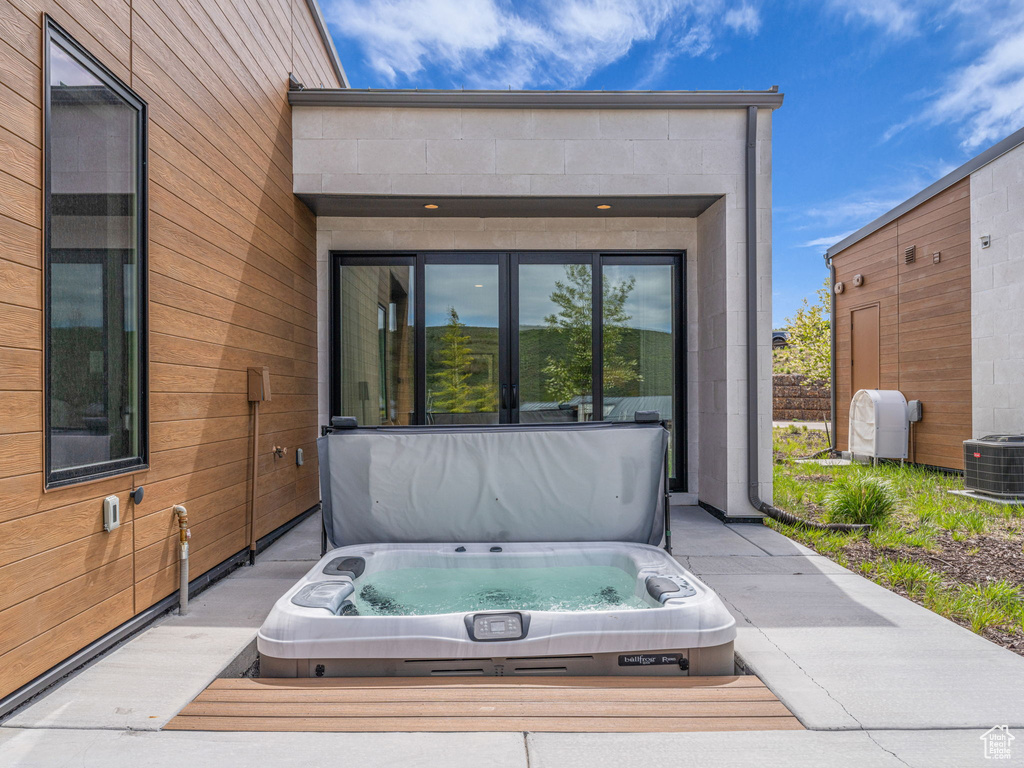View of patio featuring a covered hot tub and cooling unit