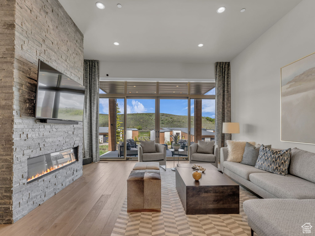Living area featuring a fireplace, hardwood / wood-style flooring, recessed lighting, and plenty of natural light