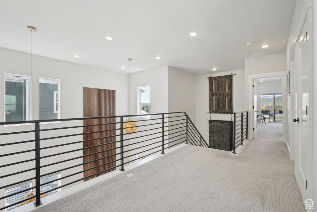 Corridor featuring an upstairs landing, carpet flooring, and recessed lighting