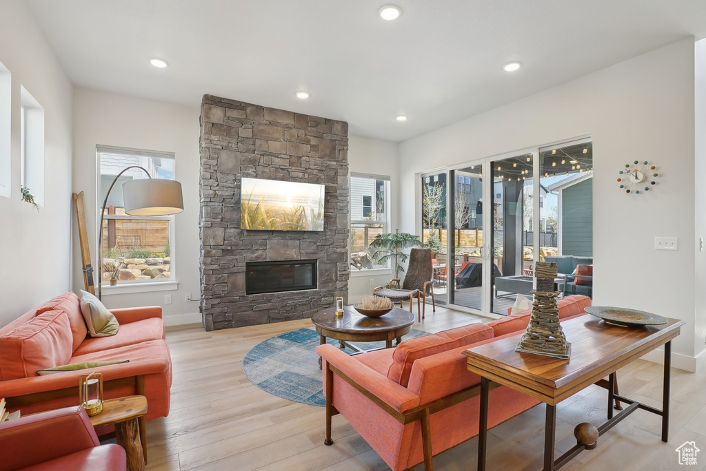 Living room featuring a fireplace, light wood finished floors, recessed lighting, and baseboards