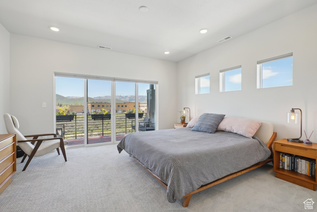 Bedroom with access to exterior, light colored carpet, recessed lighting, and a mountain view