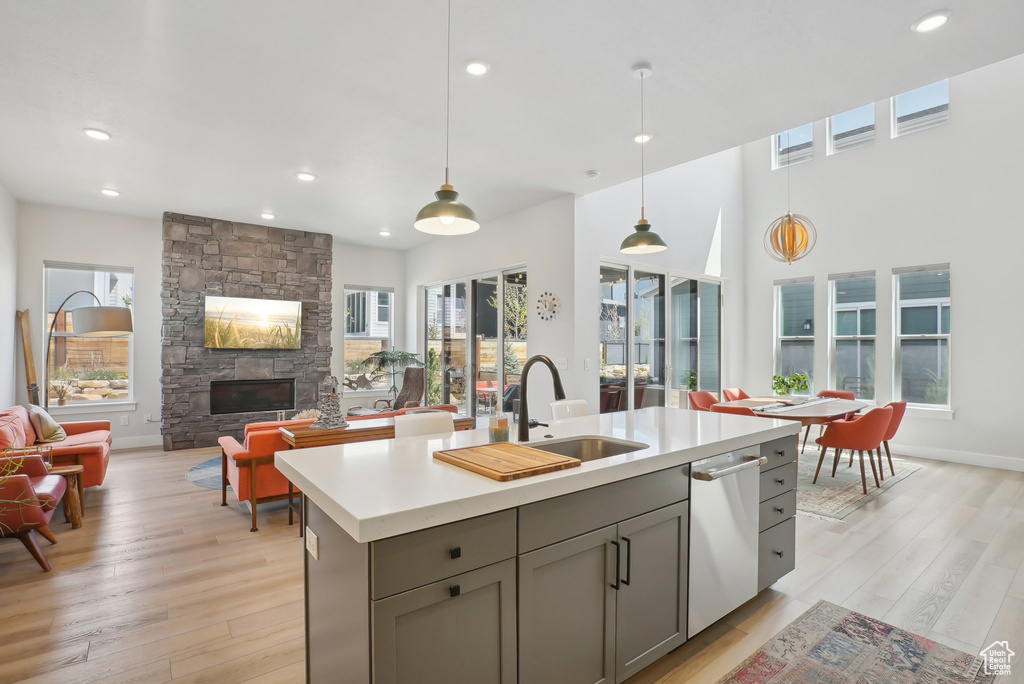 Kitchen featuring a sink, gray cabinets, dishwasher, light countertops, and recessed lighting