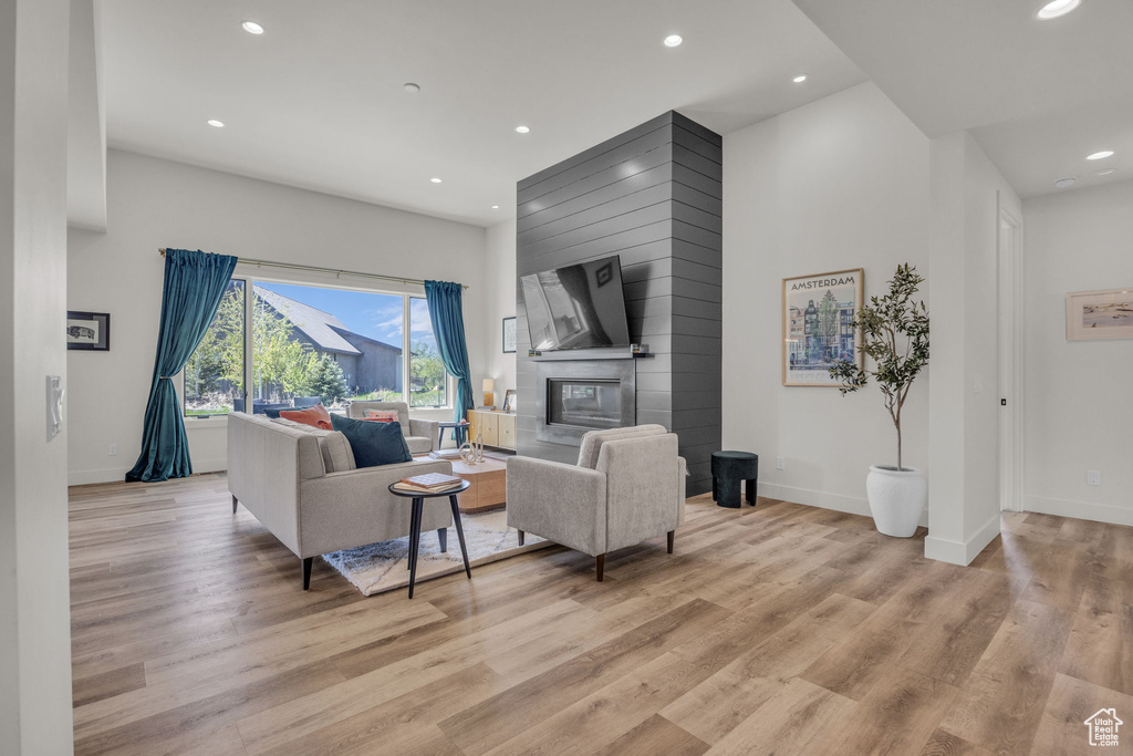 Living area featuring recessed lighting, light wood finished floors, baseboards, and a fireplace