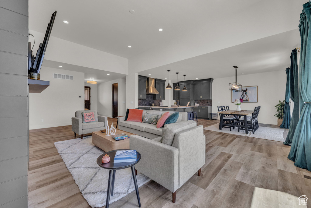 Living area with light wood-style floors, a chandelier, recessed lighting, and baseboards