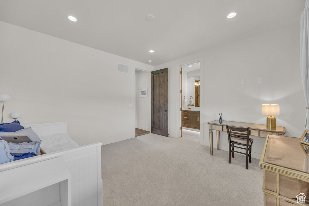 Bedroom with light colored carpet, recessed lighting, and ensuite bath