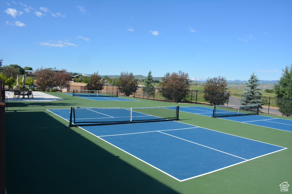 View of tennis court with community basketball court and a mountain view