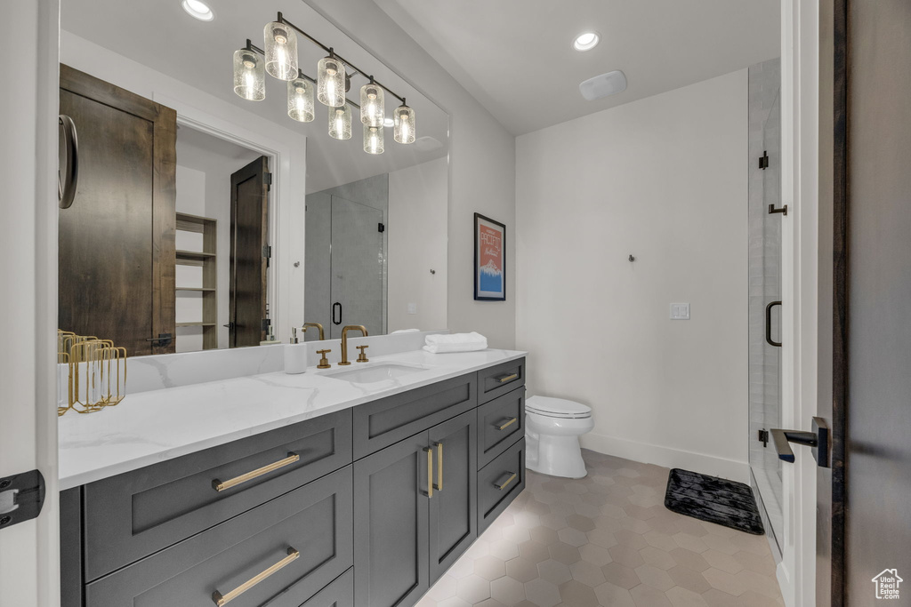Bathroom with vanity, a shower stall, toilet, tile patterned flooring, and recessed lighting
