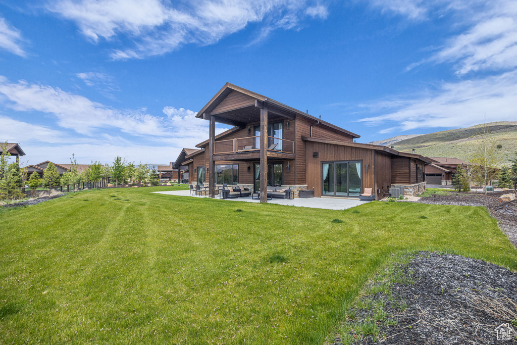Back of house with a balcony, a patio, central air condition unit, and a mountain view
