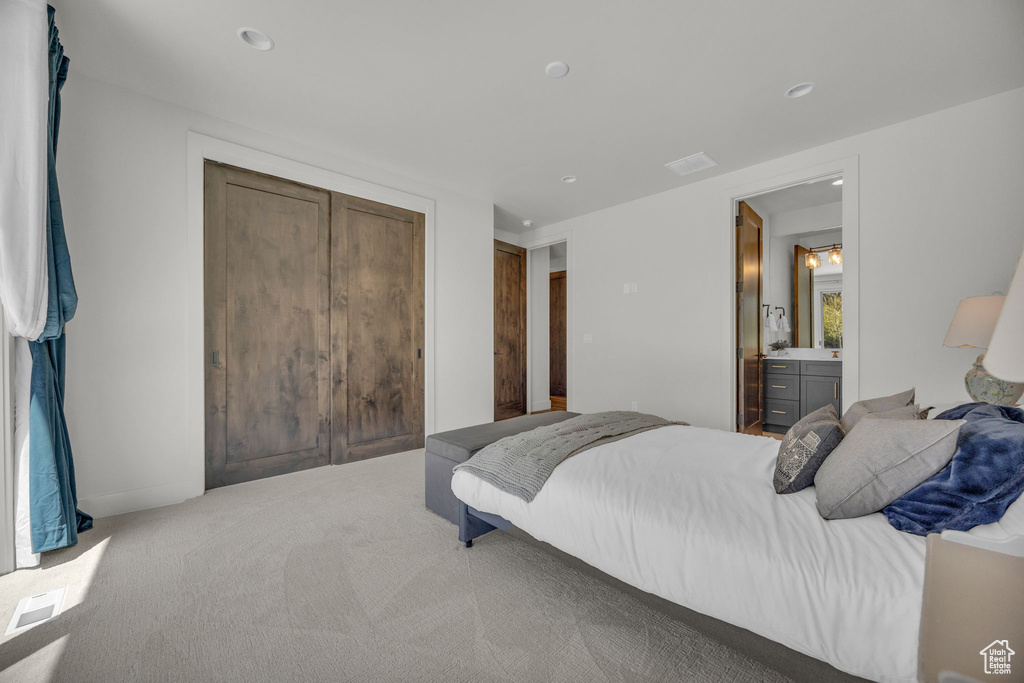 Bedroom featuring light carpet, recessed lighting, and a closet