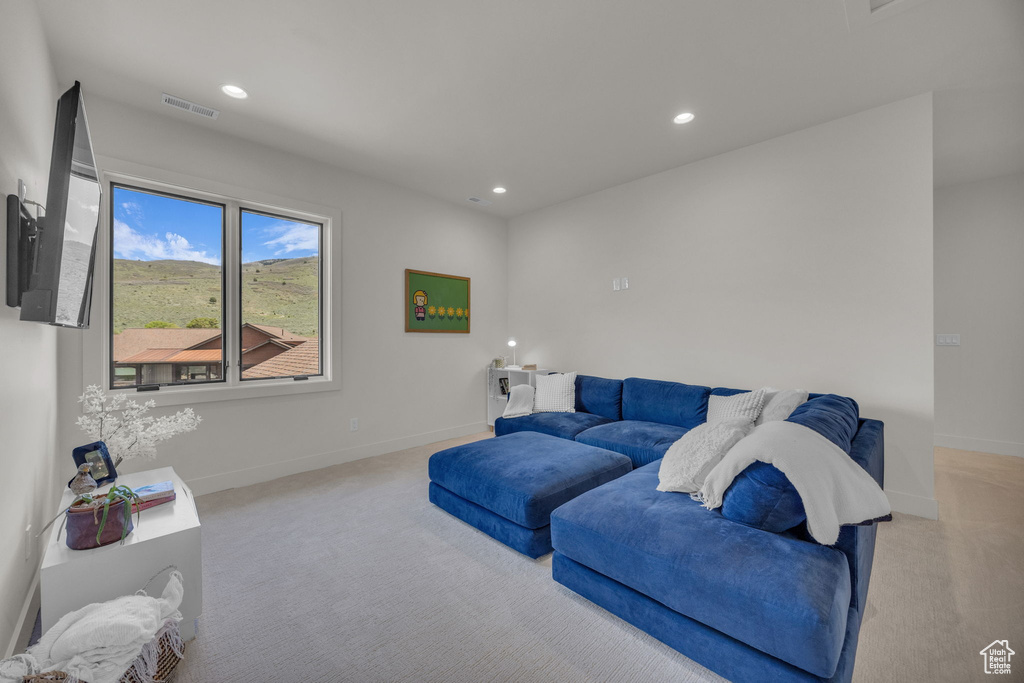 Carpeted living room featuring recessed lighting and baseboards