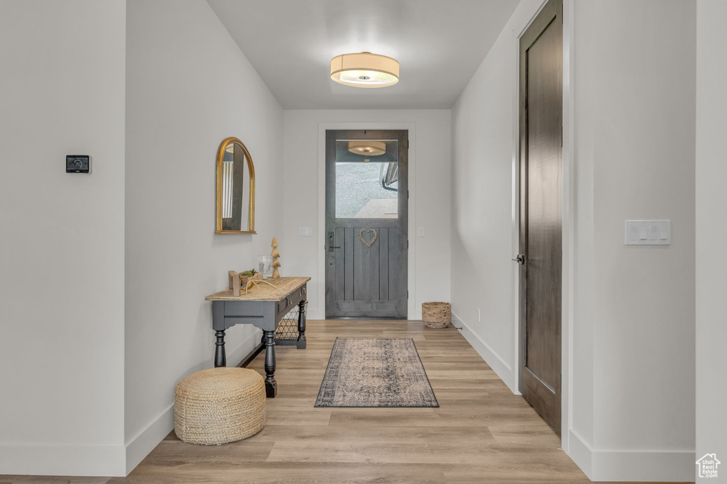 Entrance foyer with baseboards and light wood-style flooring