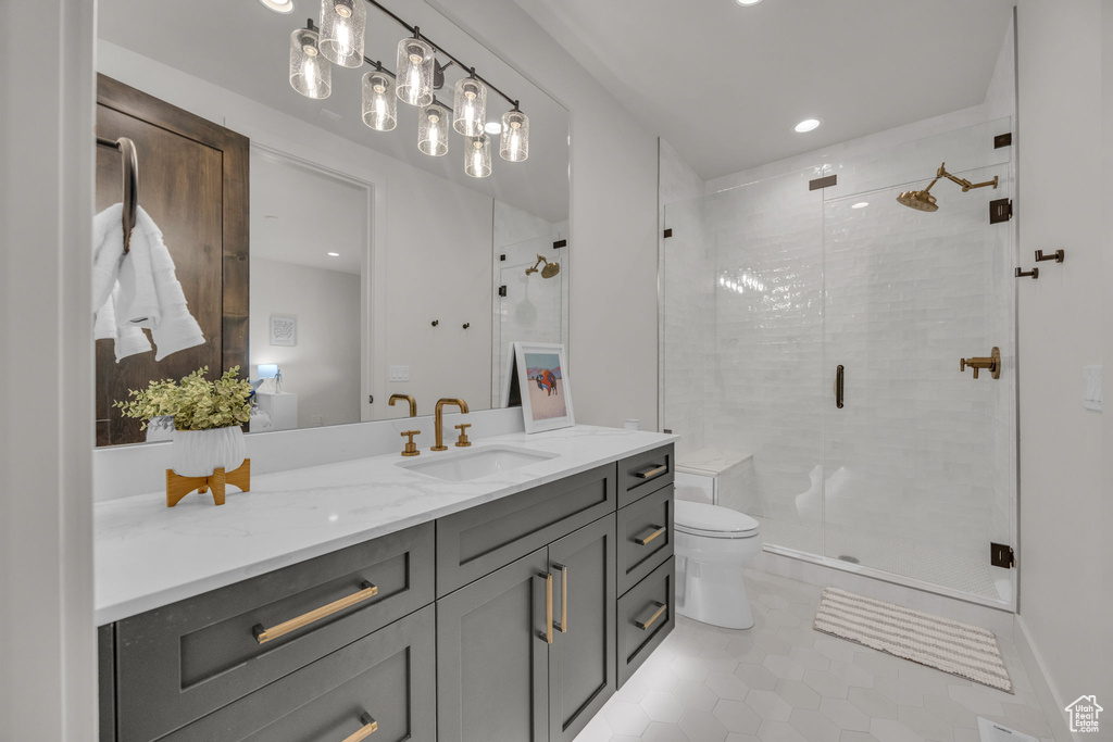 Bathroom featuring tile patterned flooring, vanity, a shower stall, toilet, and recessed lighting