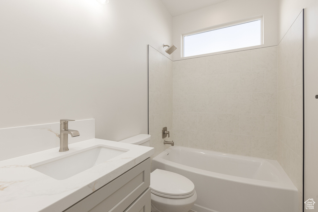 Full bathroom featuring toilet,  shower combination, and vanity