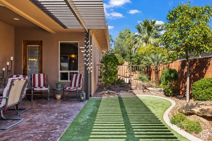 Fenced backyard featuring a patio and an area to practice putting