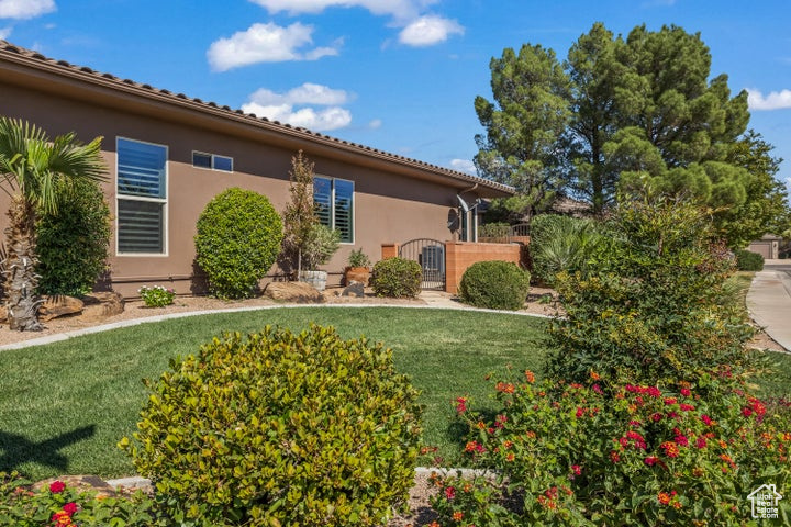 View of front of property with stucco siding, a front lawn, and a gate
