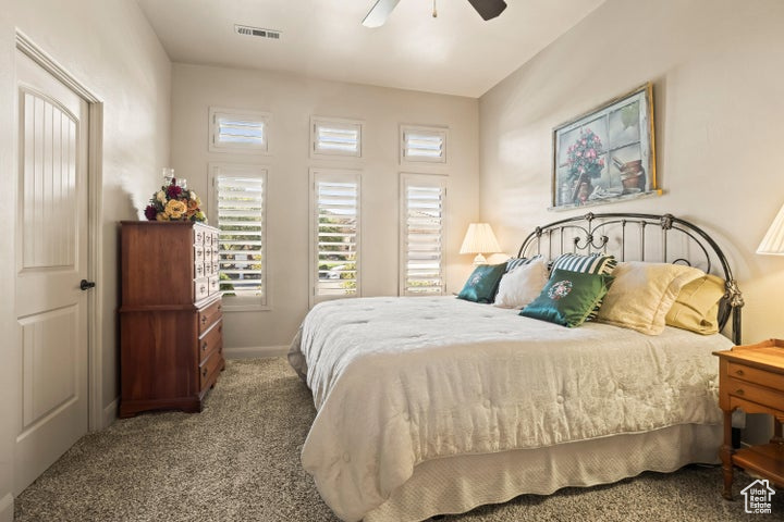 Carpeted bedroom featuring baseboards and ceiling fan