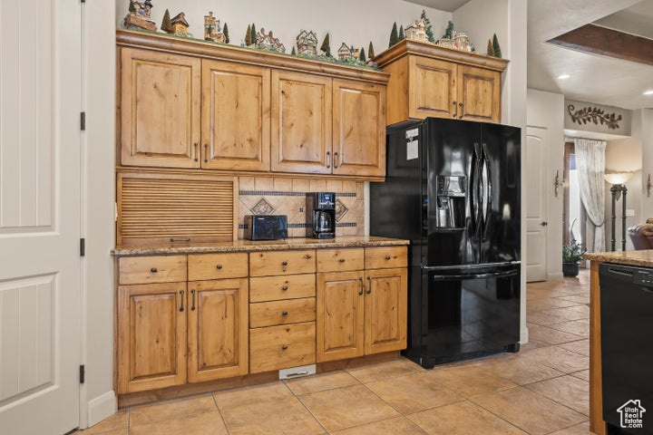 Kitchen featuring black appliances, tasteful backsplash, light stone countertops, recessed lighting, and baseboards