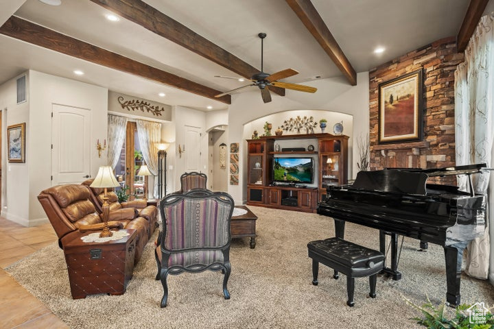 Living room featuring a ceiling fan, beam ceiling, recessed lighting, and arched walkways