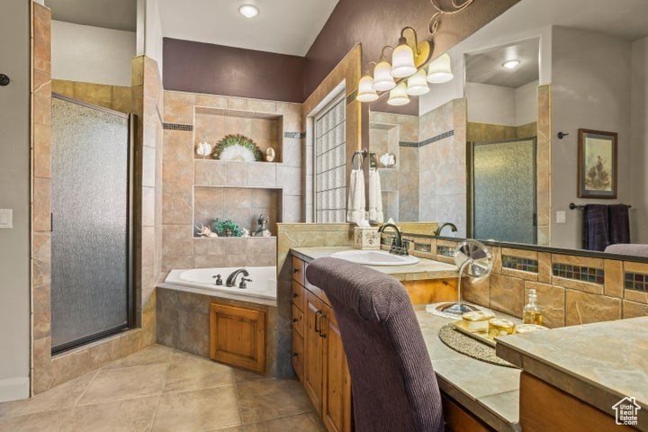 Full bathroom featuring a stall shower, vanity, a bath, and tile patterned floors