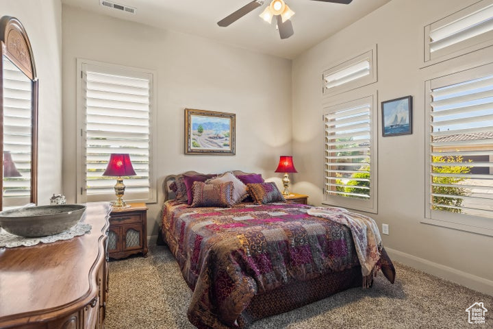 Carpeted bedroom featuring baseboards and ceiling fan