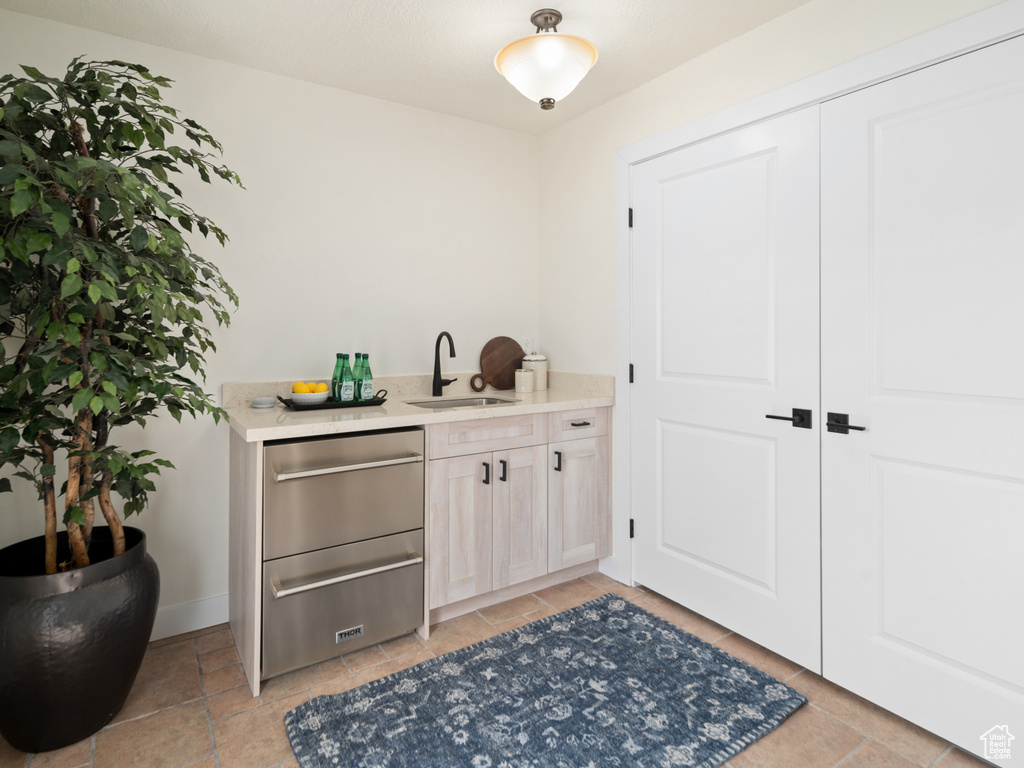 Bar area with a sink, baseboards, and dishwasher