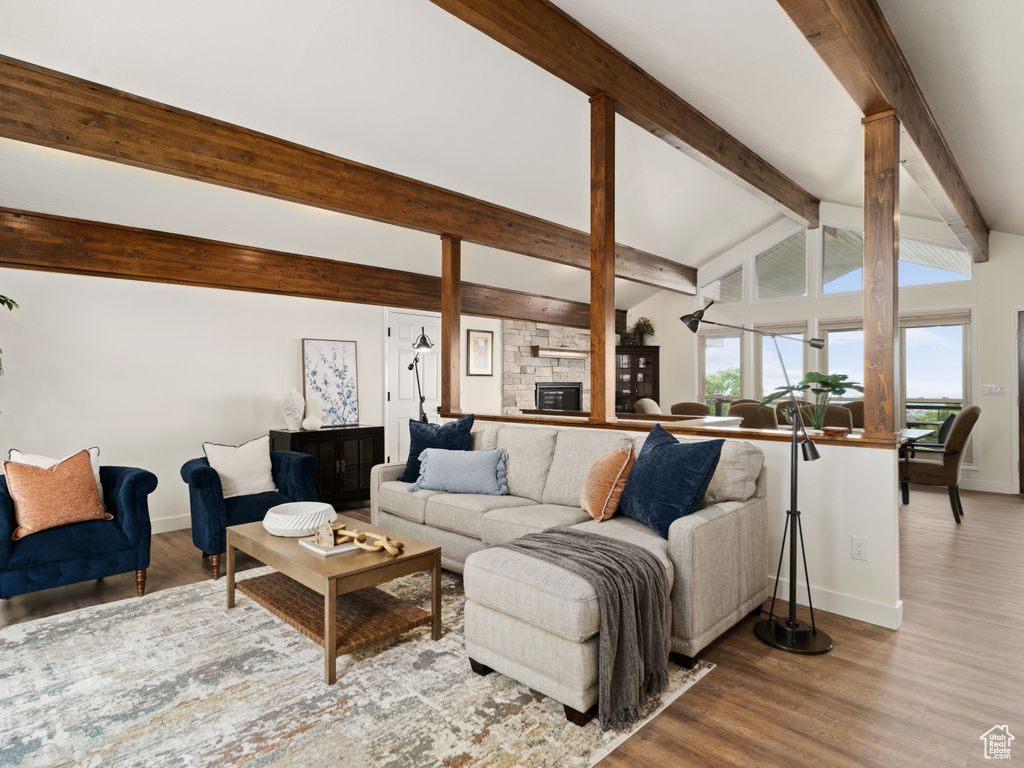 Living room featuring baseboards, wood finished floors, and ornate columns