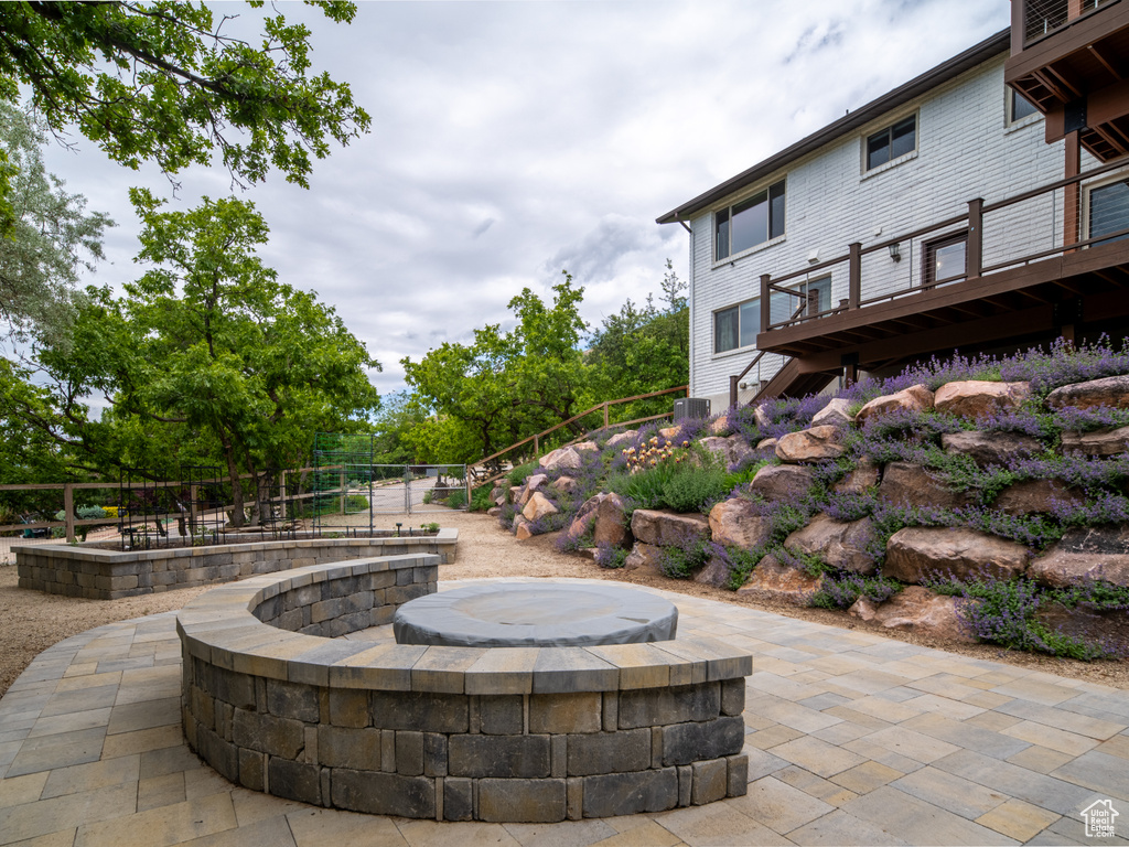 View of patio with a deck, stairs, a fire pit, and central AC unit