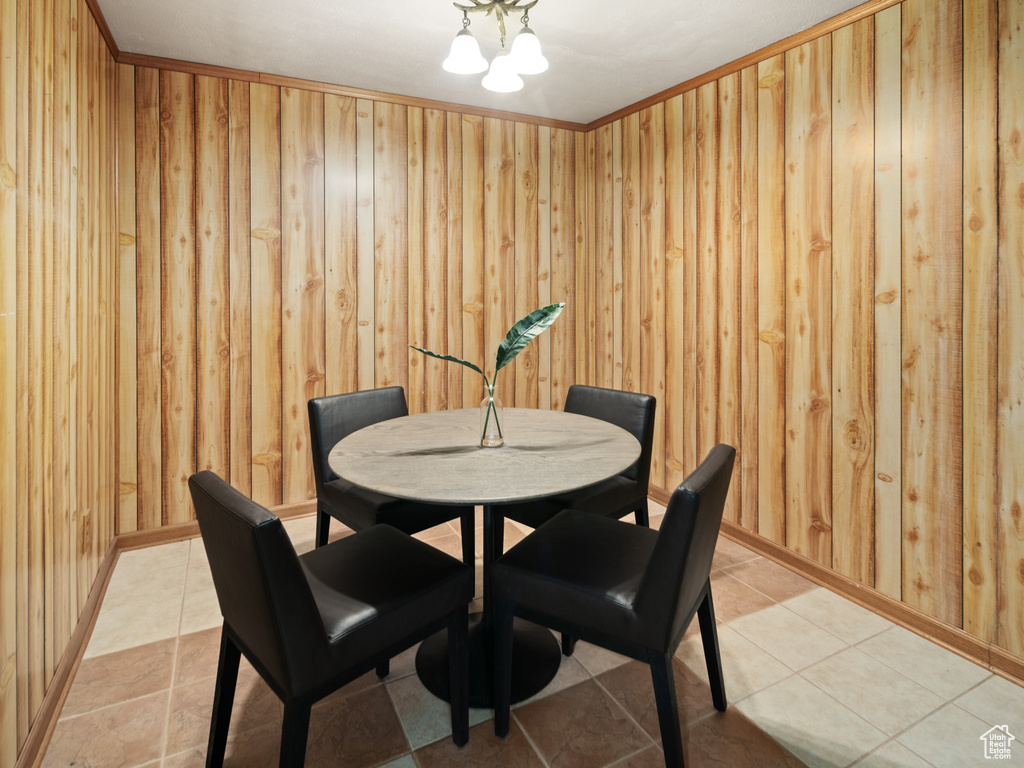 Dining space featuring wood walls and light tile patterned floors