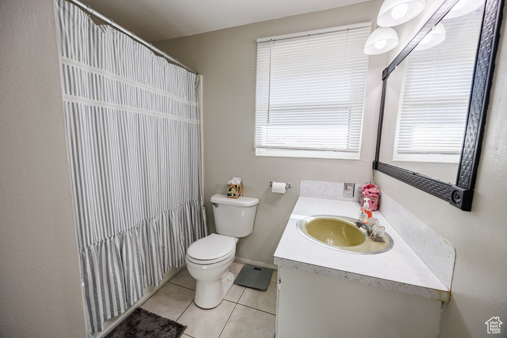 Full bathroom with tile patterned flooring, toilet, vanity, and curtained shower
