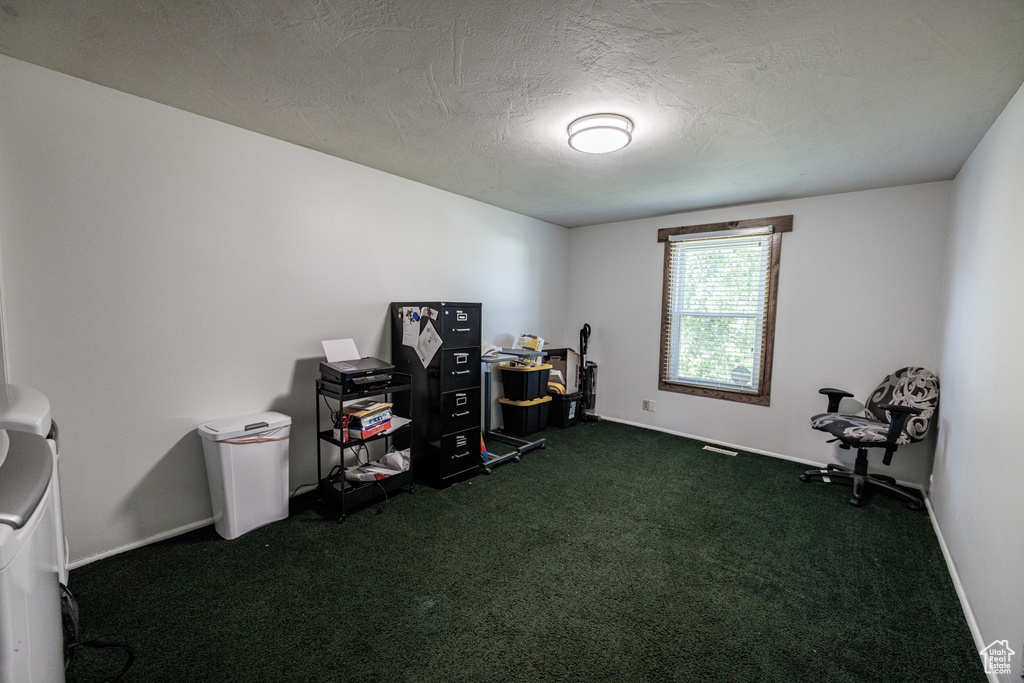 Home office with dark carpet, a textured ceiling, and baseboards