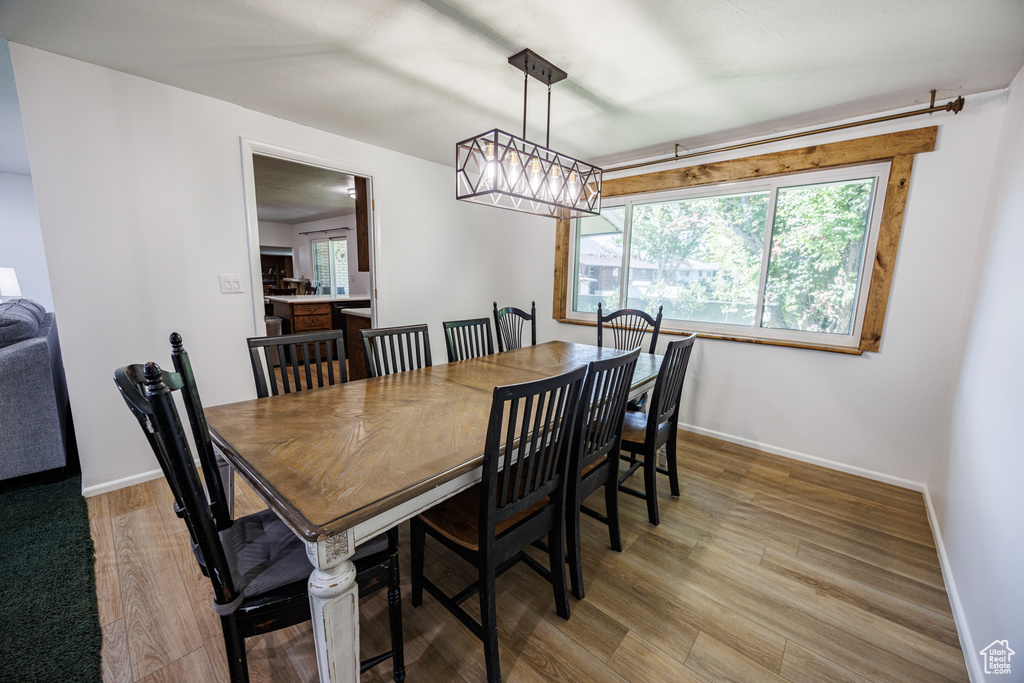 Dining space featuring light wood finished floors, baseboards, and a chandelier