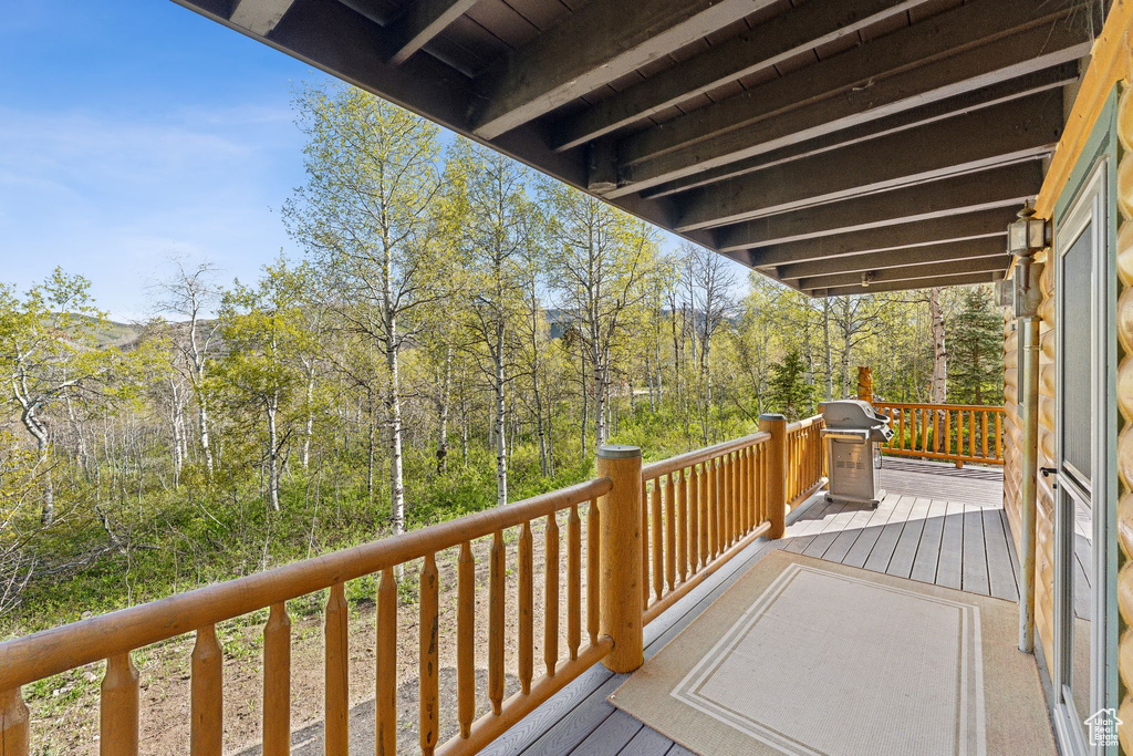 Wooden terrace featuring a grill