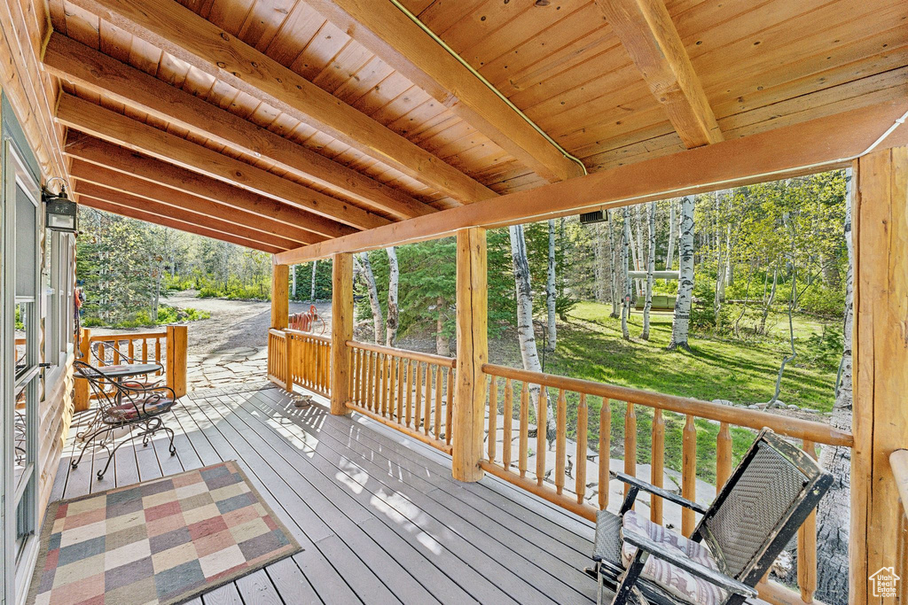 Wooden terrace featuring view of wooded area