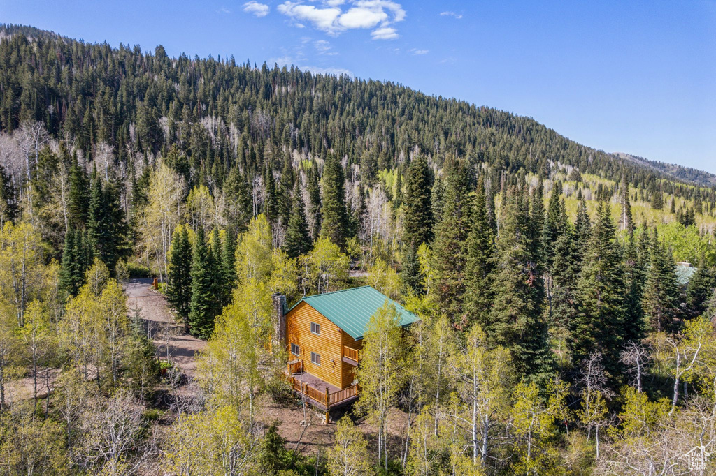 View of subject property featuring a forest and a mountainous background