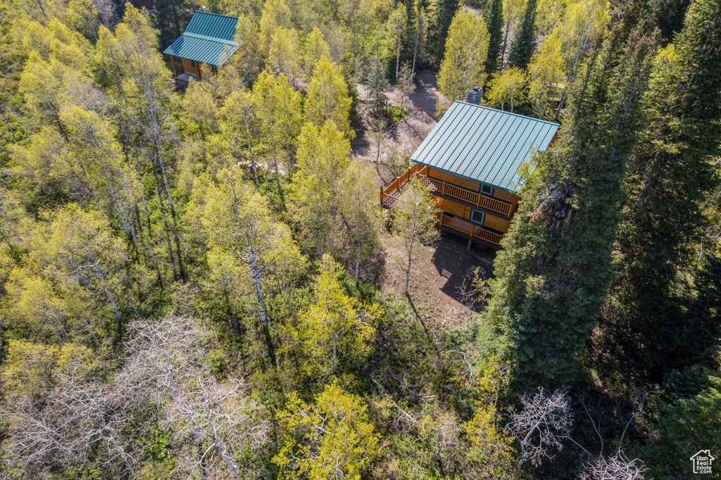 Aerial view of property and surrounding area with a heavily wooded area