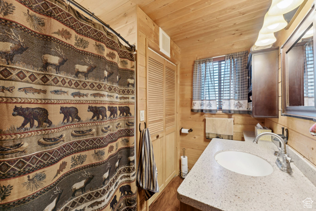 Full bath with wood ceiling, vanity, wooden walls, wood finished floors, and a shower with curtain
