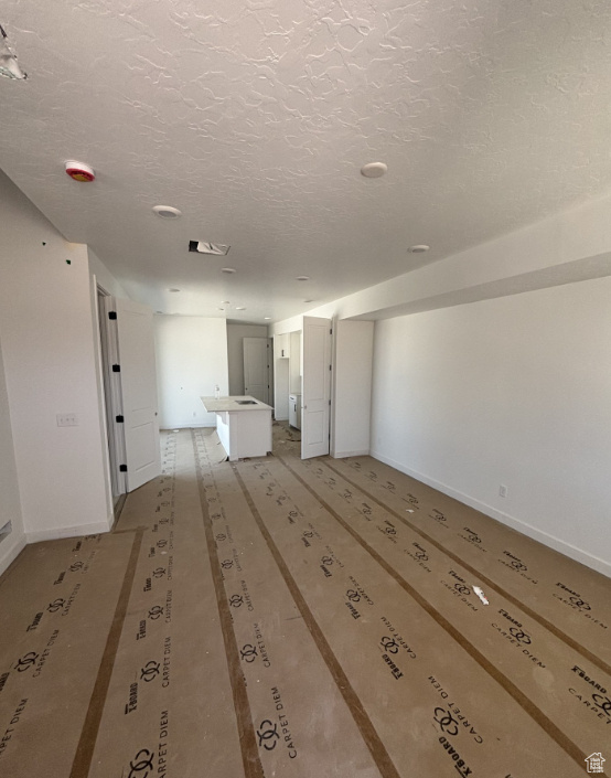 Spare room with baseboards and a textured ceiling
