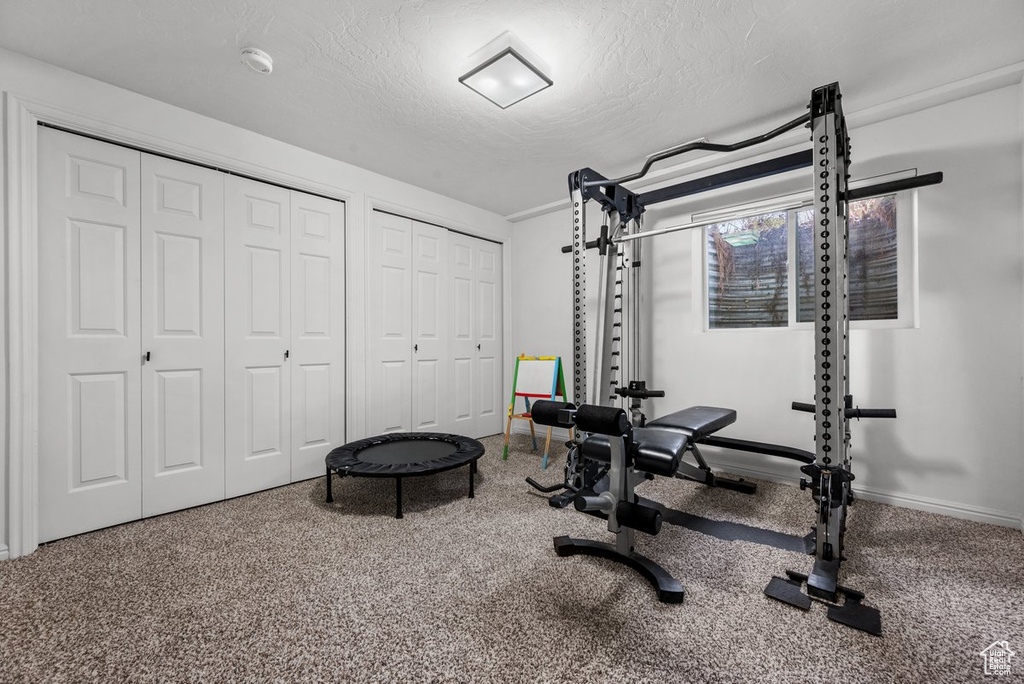 Exercise room featuring a textured ceiling and baseboards